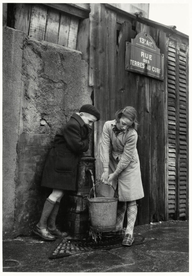 Enfants prenant de l’eau à la fontaine, rue des Terres-au-Curé