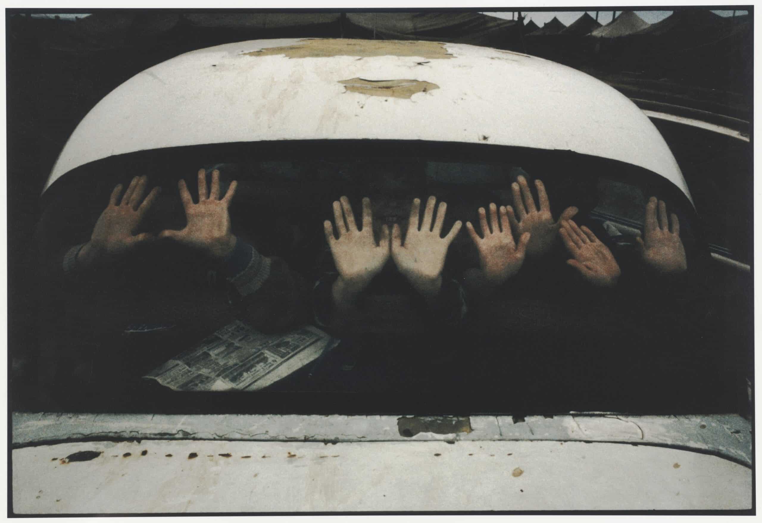 Enfants jouant dans une voiture au milieu des tentes, camp Sputnik, Sleptovsk, Ingouchie, juin 2000