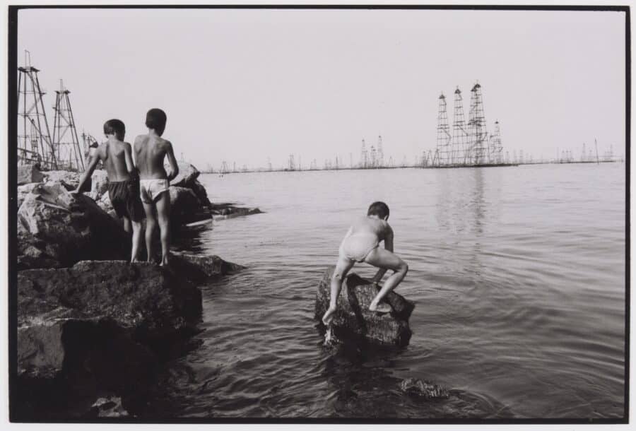 Enfants jouant dans les eaux de la mer Caspienne, non loin des plates-formes pétrolières de Bakou, Azerbaïdjan. Reportage « Enjeux du pétrole en mer Caspienne », 1998