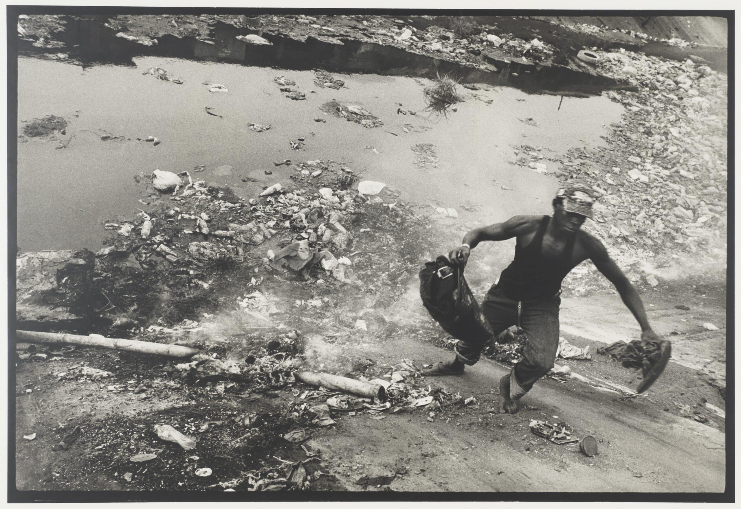 Éboueur évacuant les déchets électroniques déversés dans le canal, Lagos, Nigeria. Reportage sur les déchets électroniques, 2012